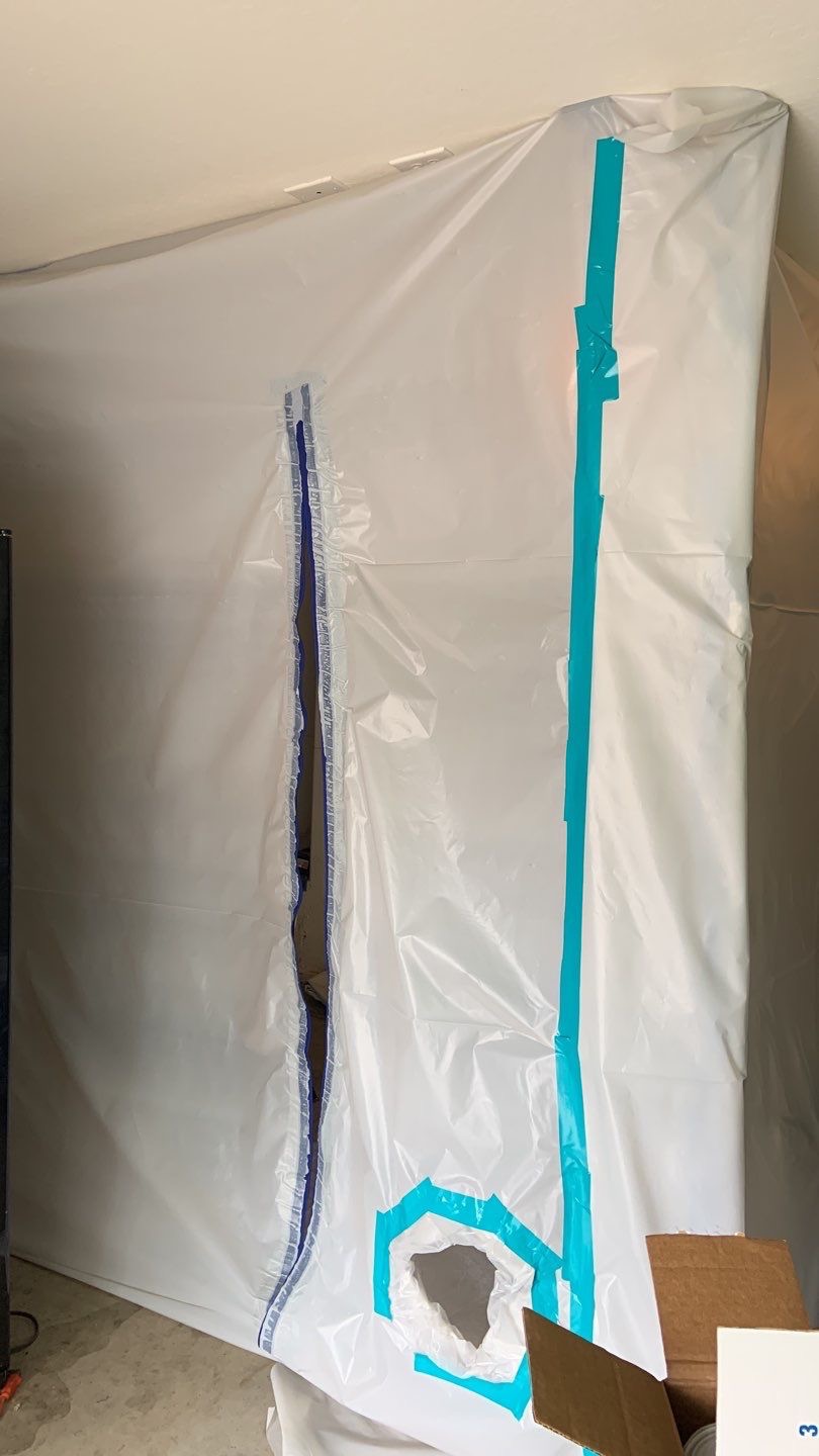 Containment with open zipper and blue tape along right side.