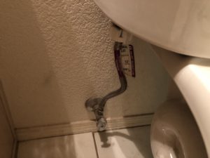 Water supply line connected to a toilet.