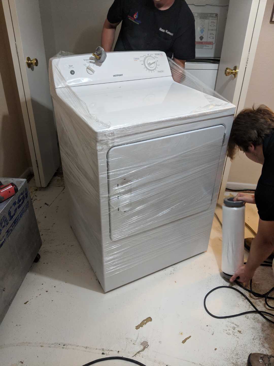 Washing machine wrapped in plastic before installation.