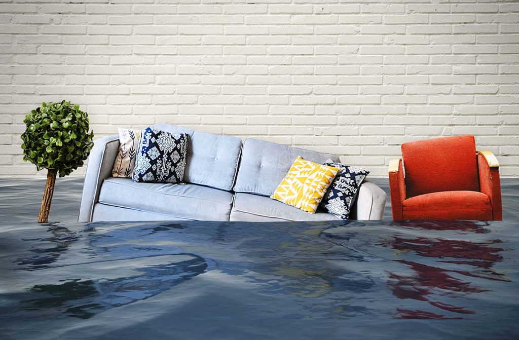Two-seater sofa and red chair floating in a flooded room